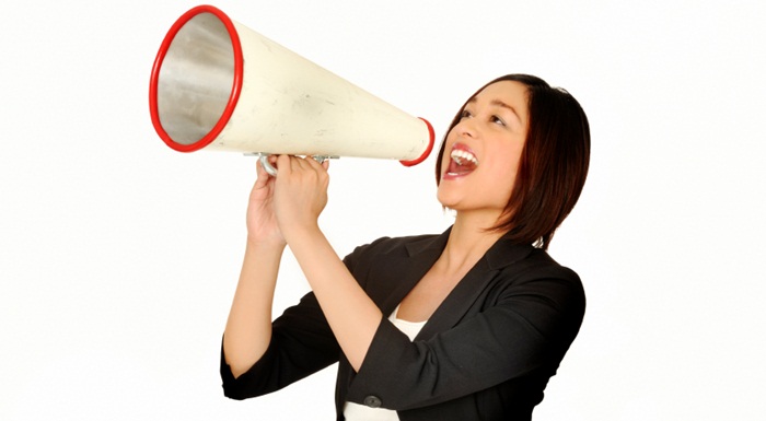 young professional woman making an announcement through a megaphone.
