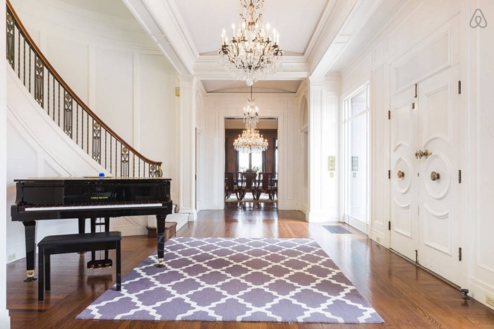 when-you-come-in-the-front-door-youre-greeted-by-an-enormous-winding-staircase-a-chandelier-and-a-piano-for-entertainment