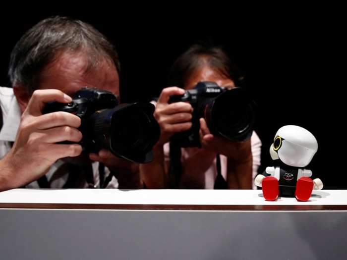 Photographers take picture of Toyota Motor Corp's Kirobo Mini robot during a photo opportunity after a news conference in Tokyo