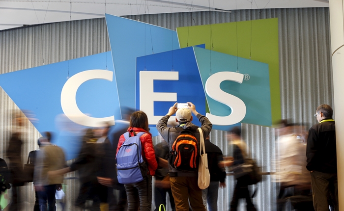 A couple takes a photo of the CES logo during the 2016 CES trade show in Las Vegas